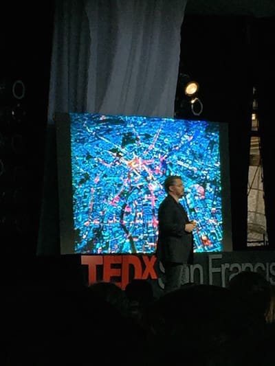 Speaker at TEDx San Francisco presenting city design map on screen