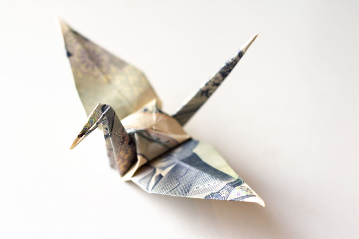 Origami crane made from Japanese yen, symbolizing financial creativity in marketing consulting.