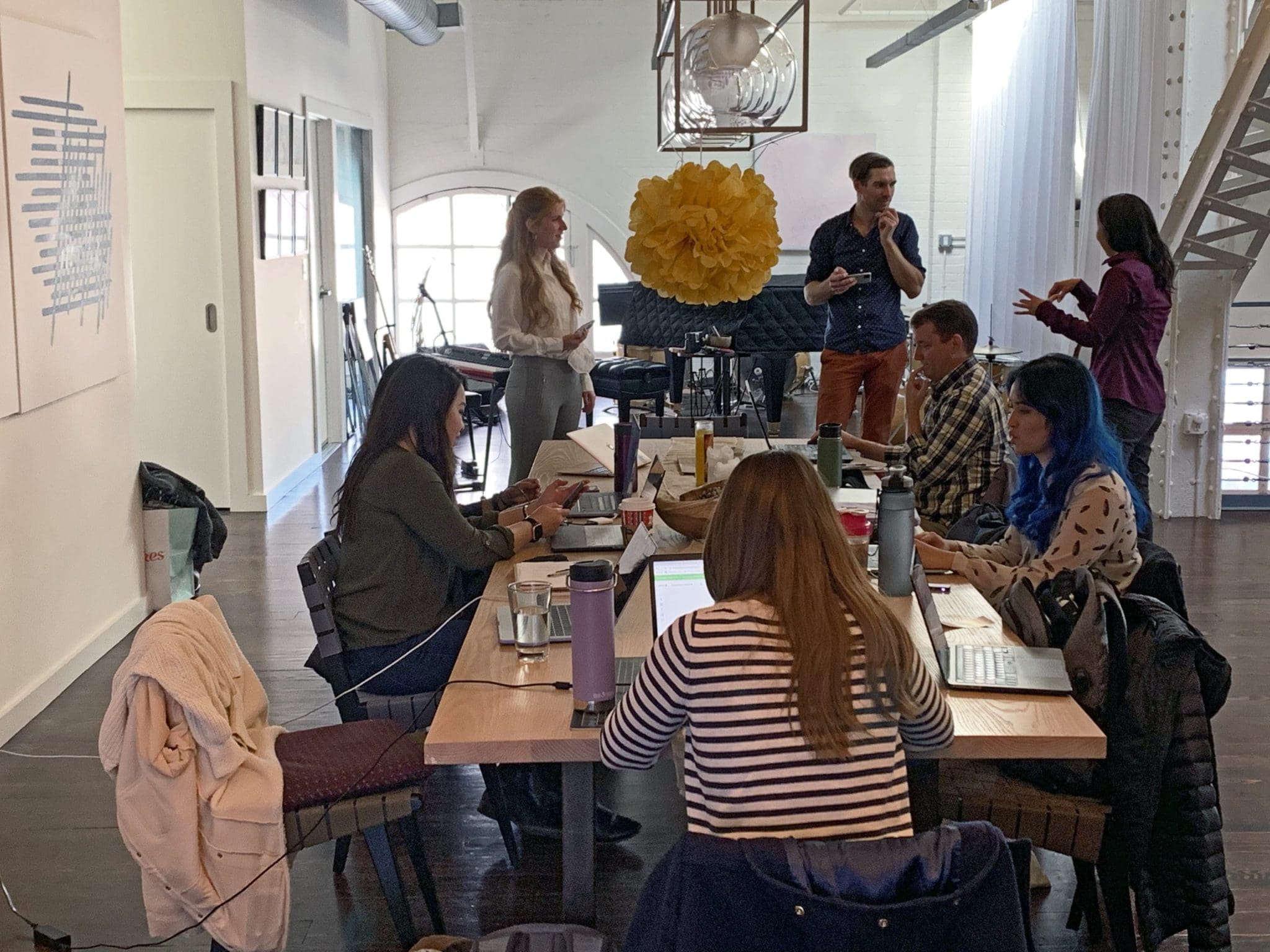 Team collaborating at a modern office table, discussing work.