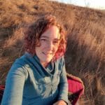 Woman enjoying a golden sunset during an outdoor hike