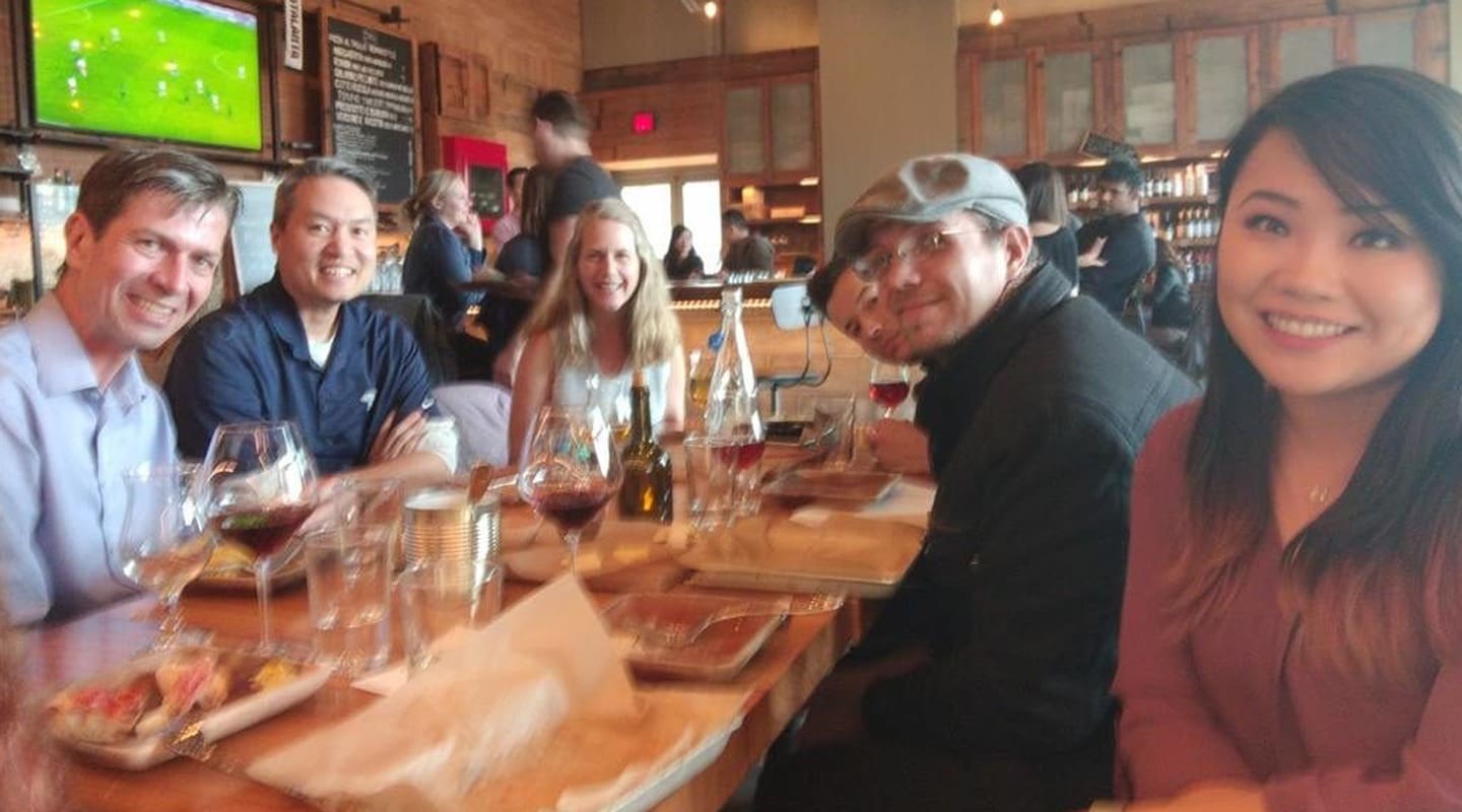 Group of friends enjoying wine and food at a restaurant during Community Day.