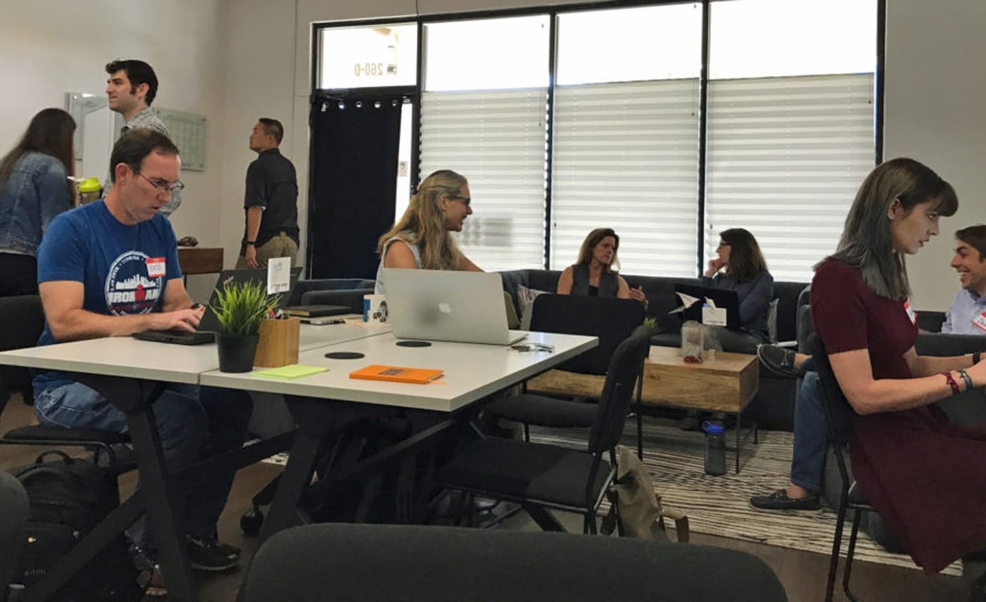 People working on laptops and collaborating in a co-working space, a scene from EM Marketings First Community Day.