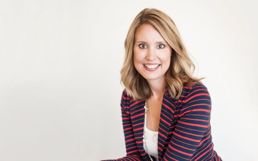 Smiling woman in a red and black striped blazer