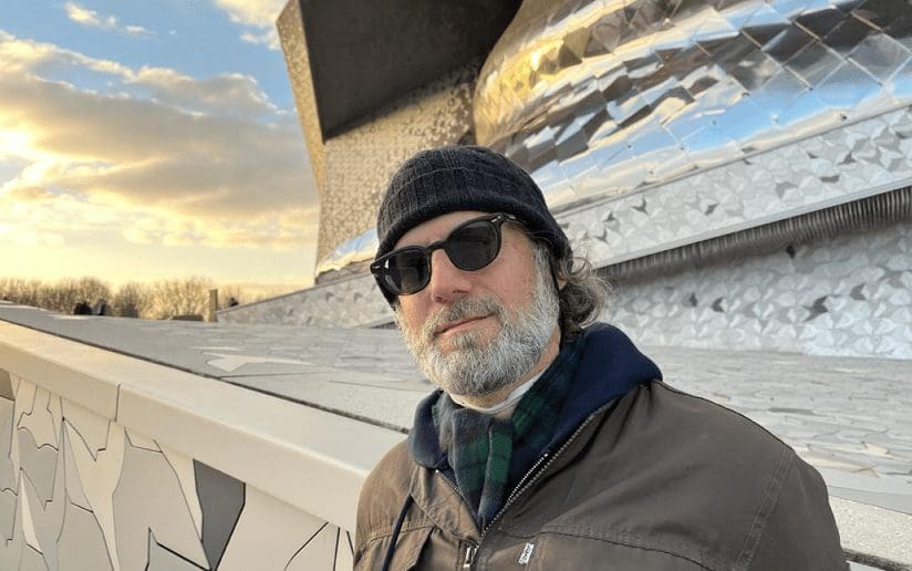 Ken Grobe, author, poses in front of the Philharmonie de Paris. The Write Stuff.