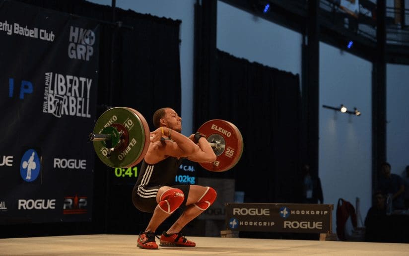 Weightlifter Michael Macon in action at Liberty Barbell, lifting a heavy barbell during a competition.