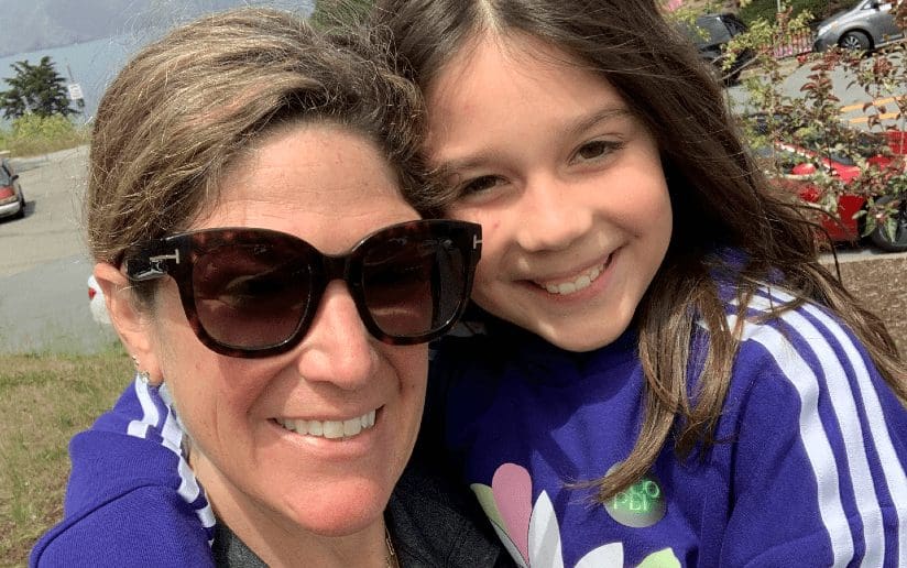 Aliyah Schneckenberger with her daughter, smiling outdoors. Consulting success.