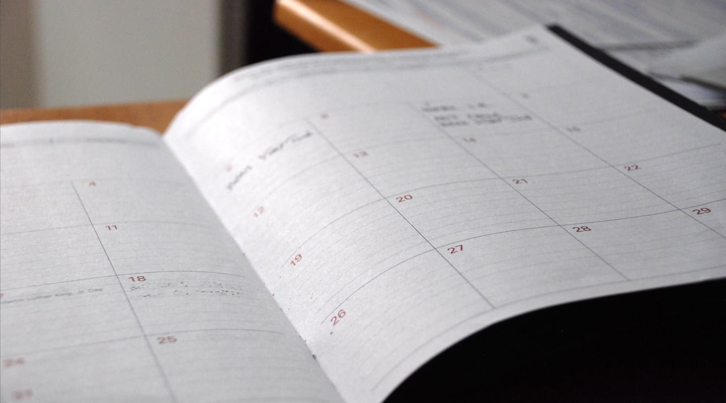 Open calendar book with dates and handwritten entries, ready for content planning.