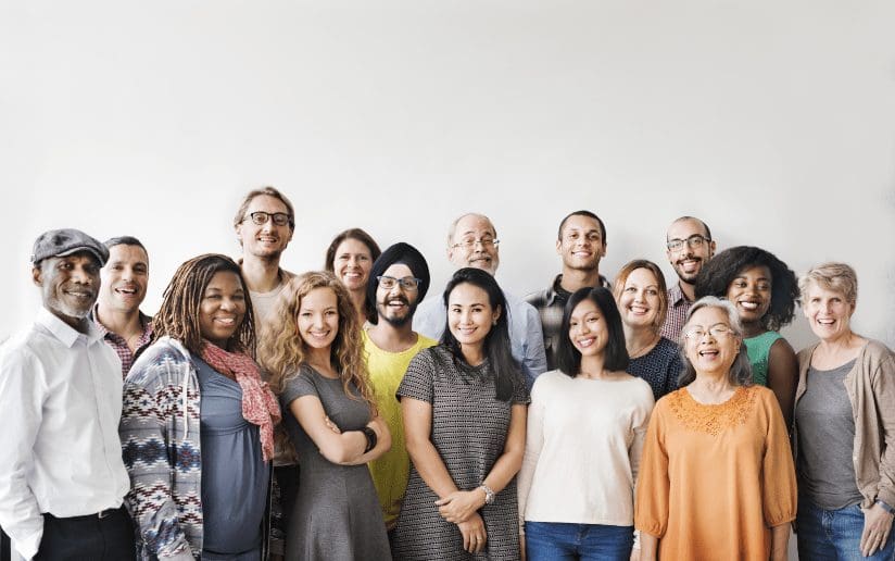 Diverse group of smiling people standing together, representing diversity and inclusion.