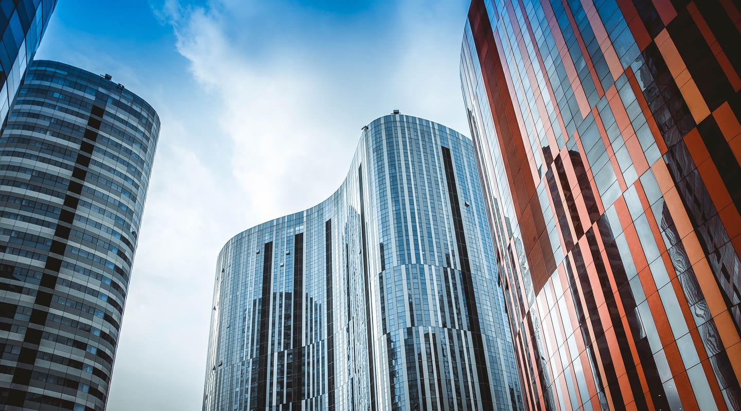 Modern skyscrapers against a blue sky, reflecting light. Architecture for business.
