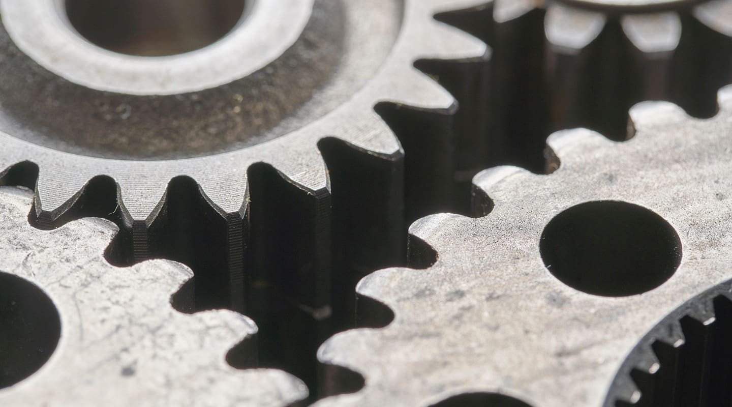 Close-up of interlocking metal gears, representing product management processes.