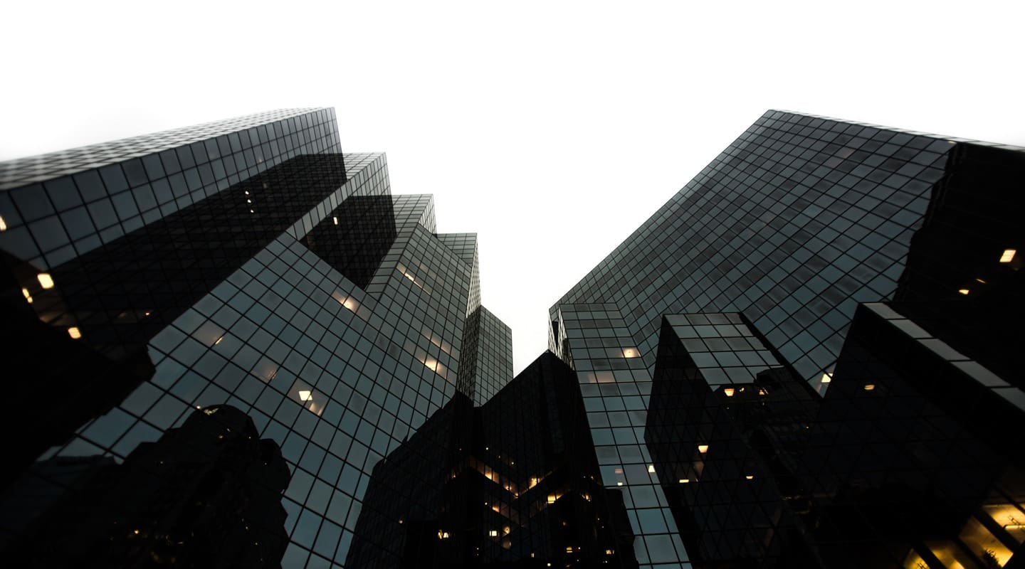 Low-angle view of modern glass skyscrapers reflecting the sky. Growth marketing strategies.