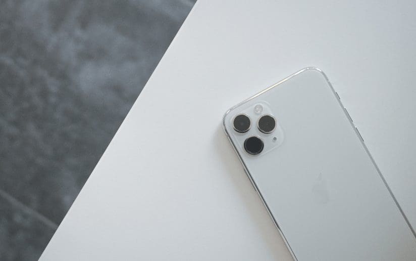 Close-up of iPhone 11 Pro camera lenses on a white surface