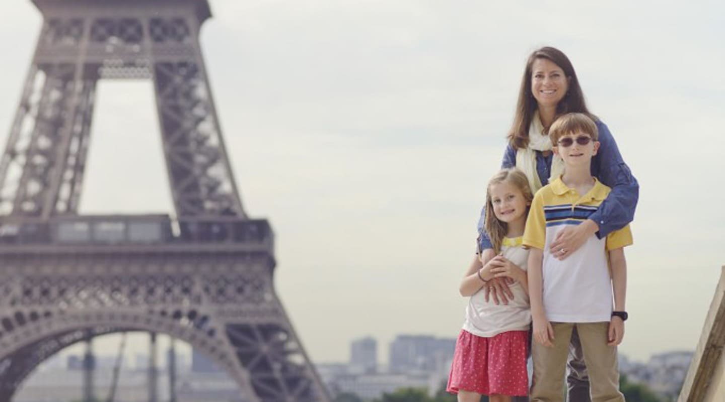 Family posing in front of the Eiffel Tower in Paris