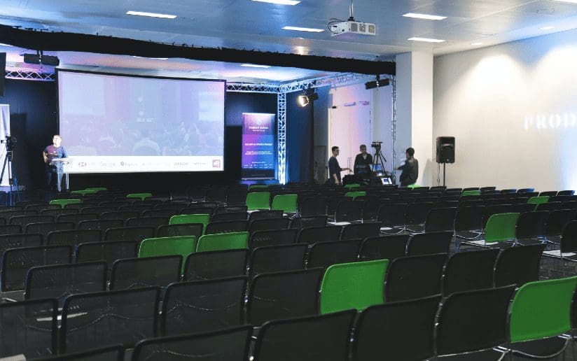 Empty conference hall with stage and screen, ready for a virtual tradeshow or user conference.