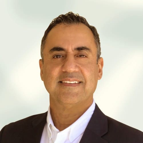 Smiling man in a suit and white shirt, professional headshot