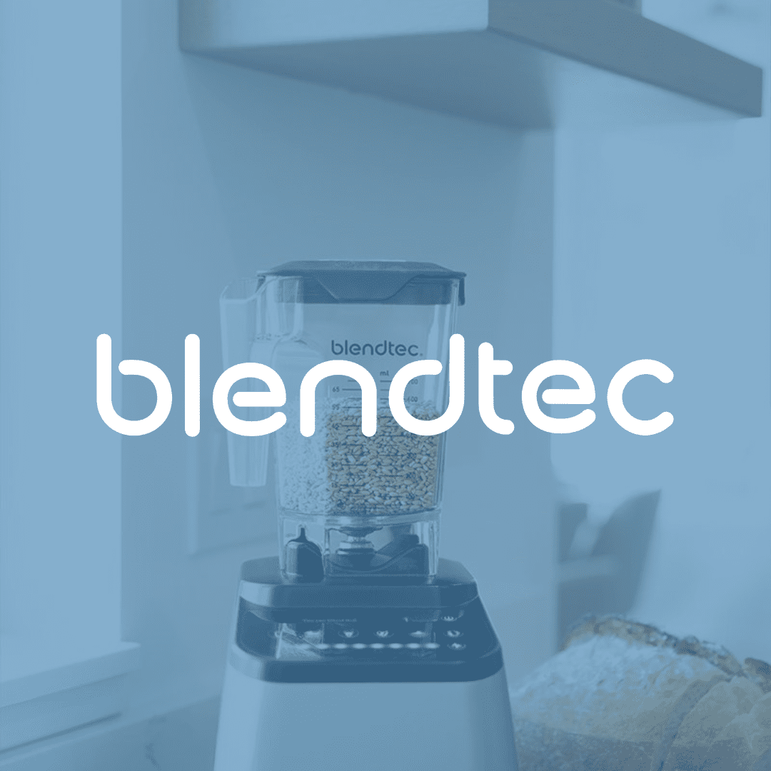 Blendtec blender with grains in a kitchen, ready to blend a smoothie.