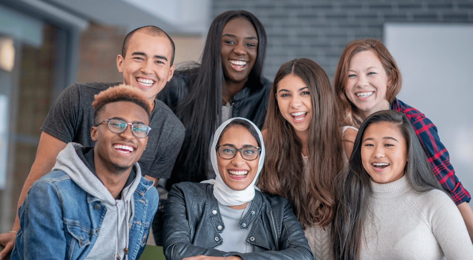 Diverse group of students smiling and laughing together, promoting inclusion.