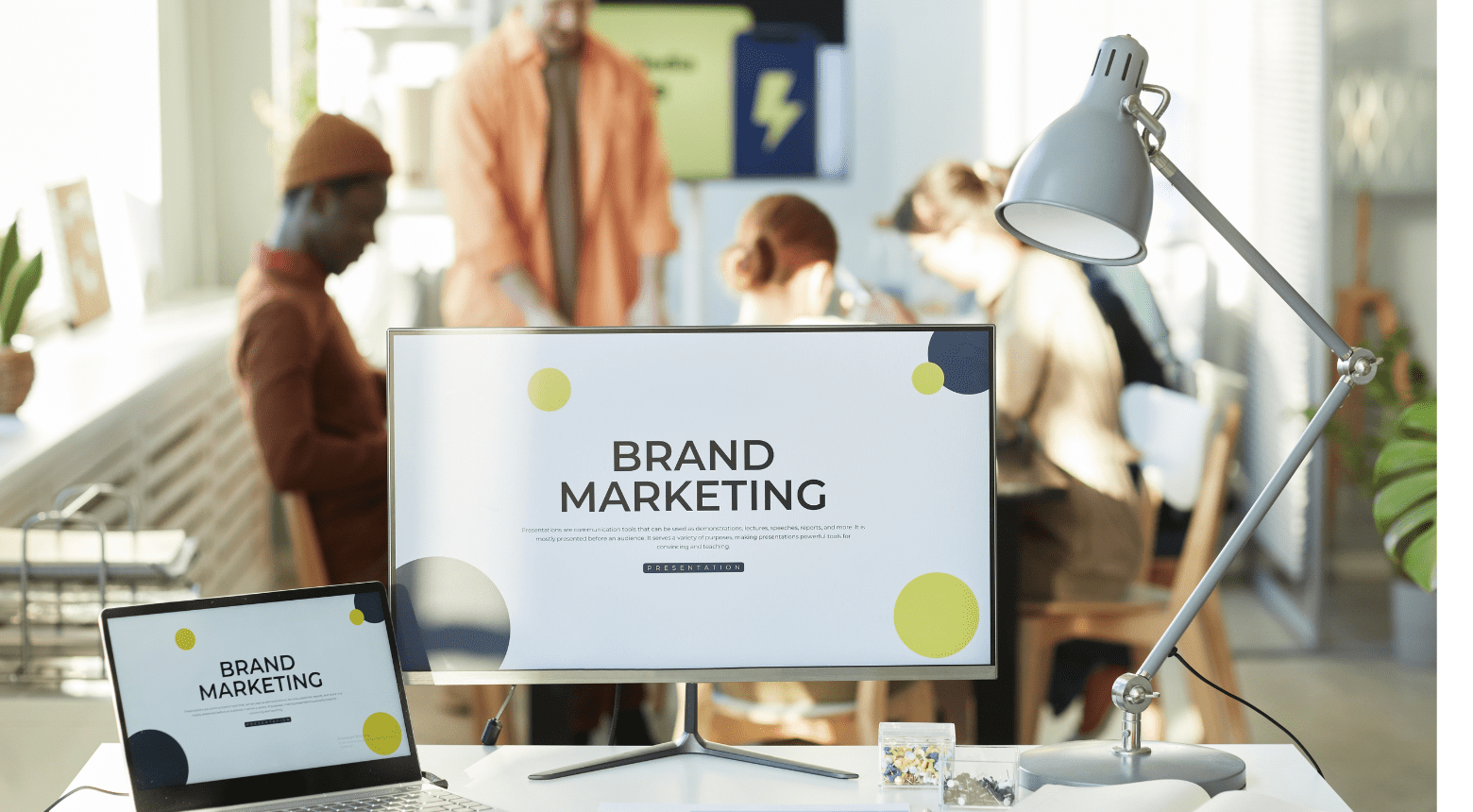 Team collaborating on brand marketing strategy, presentation on screen, laptop open.